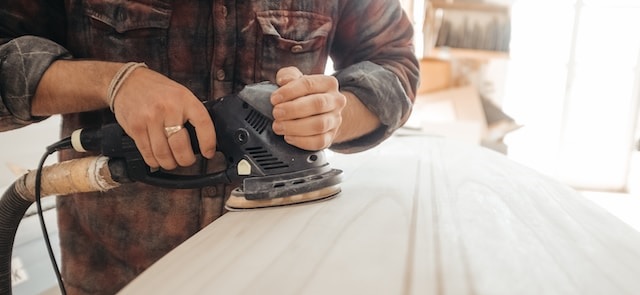 a man sanding a board